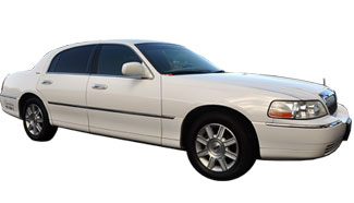 A bride being helped out of limousine by chauffeur